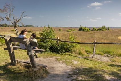 Moeder en zoon op een bankje in Nationaalpark Dwingelderveld.