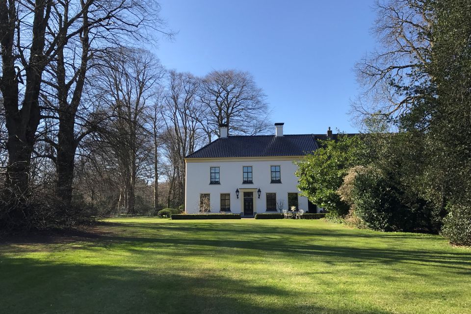 Een gebouw op een landgoed met veel groen.