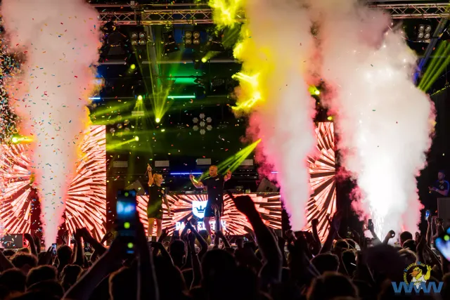 Spectaculaire avondsfeer tijdens het Dance Event op de Woerdense VakantieWeek, met lichtshows, confetti en een enthousiast publiek.