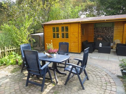 Tafel met stoelen en tuinhuis.