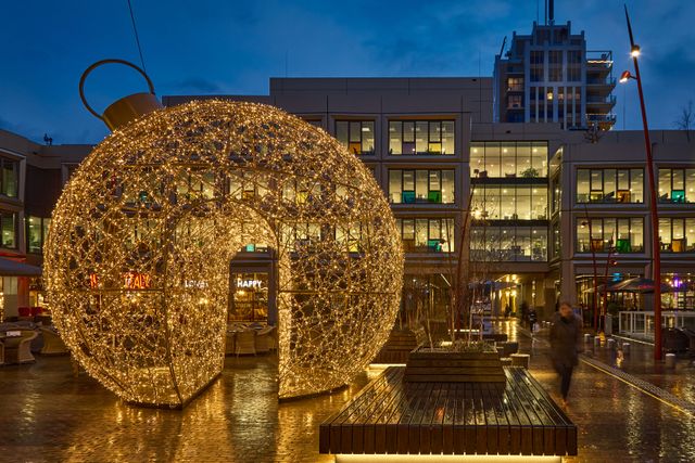 Een ronde kerstbal die verlicht is op het Stadhuisplein.