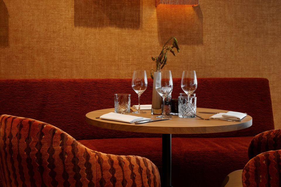 Hotel Van der Valk Woerden, Woerden, Groene Hart, sfeervol gedekte tafel met warme kleuren, designstoelen en luxe ambiance voor culinair dineren.