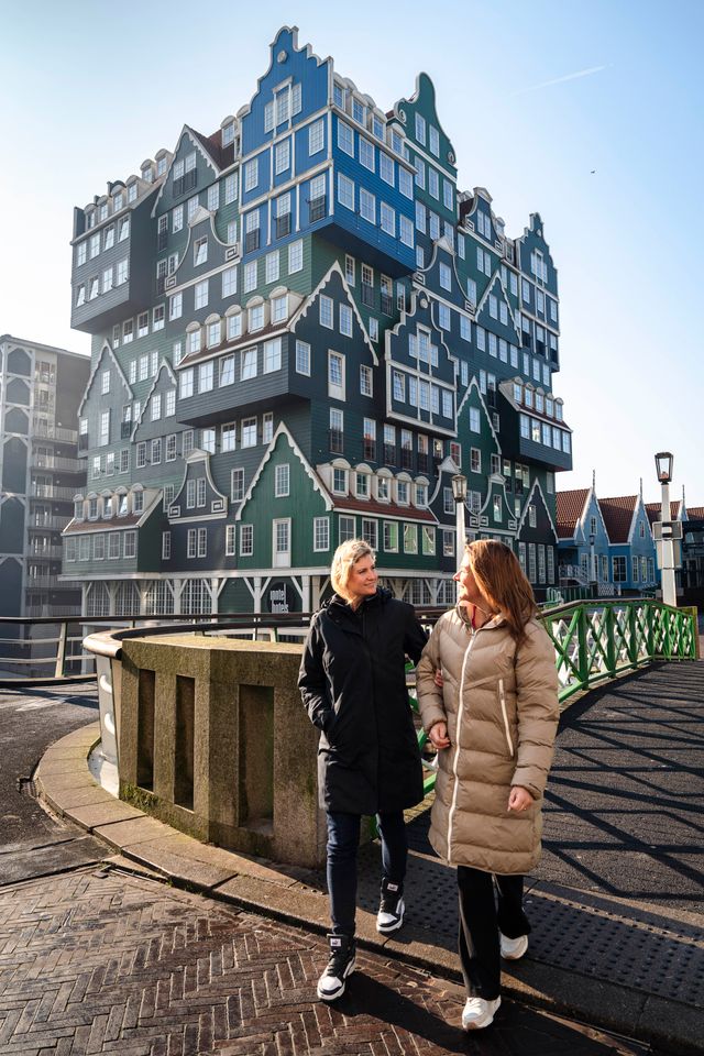 Een foto van het Inntel Hotel Amsterdam Zaandam in het Stadshart van Zaandam. Voor het hotel staan twee dames.