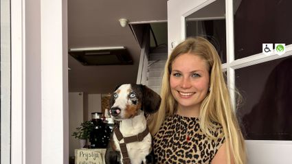 Eigenaresse van Het Roze Winkeltje in Woerden met hond in de deuropening, gezellige tweedehandswinkel in de binnenstad.