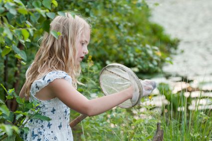 Meisje bekijkt de inhoud van een schepnetje