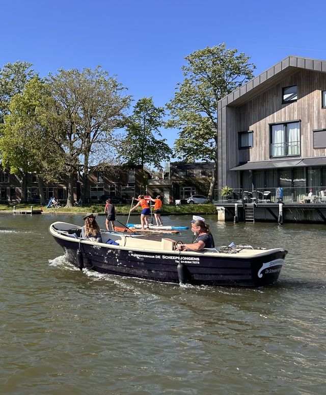 Sloepverhuur De Scheepsjongens in Woerden, varen met een elektrische sloep over de Singel langs Defensie-eiland in het Groene Hart, met suppers en rondvaartboot op zonnige dag.