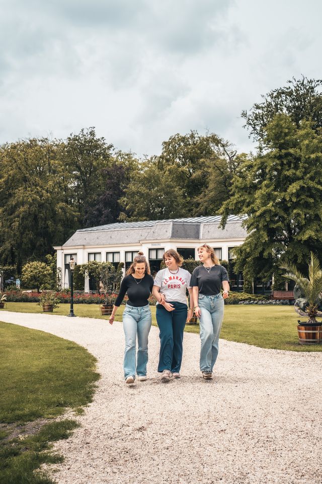 Drie vrienden die wandelen door de tuinen van Paleis Soestdijk