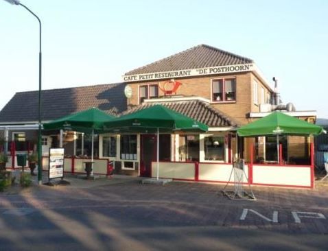 Eetcafé De Posthoorn in Montfoort, Groene Hart, karakteristiek dorpscafé met terras en groene parasols aan de straatzijde, herkenbaar horecapand voor eten en drinken in het historische stadje.