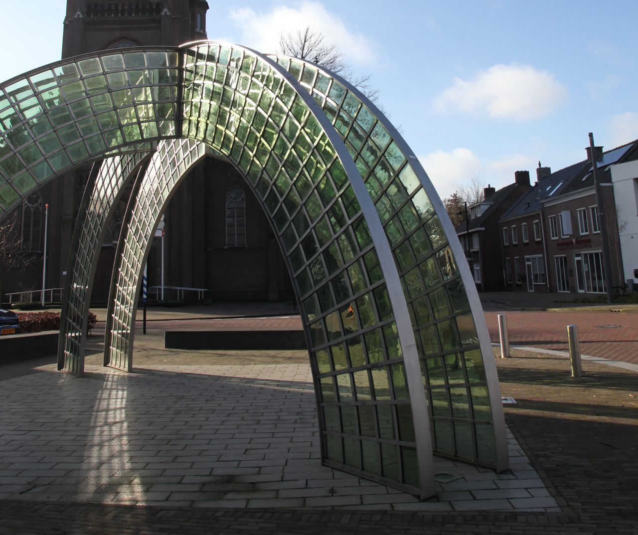 kunstwerk van kruislings gebogen staal en groen glas