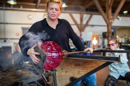 Glasblazer vormt een vaas in de Glasblazerij van het Nationaal Glasmuseum