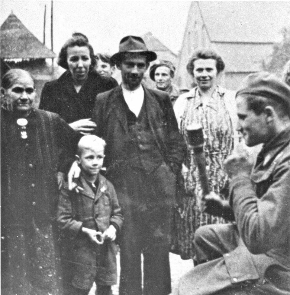 A Polish paratrooper with civilians who fled Oosterbeek, enjoys a cigarette and the attention (location photo unknown).