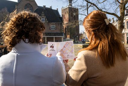 twee dames in de winter die de stadswandeling van Workum bekijken.