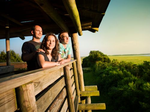 Een vader met twee kinderen kijkt uit vanaf een toren over de Kraaijenberg.