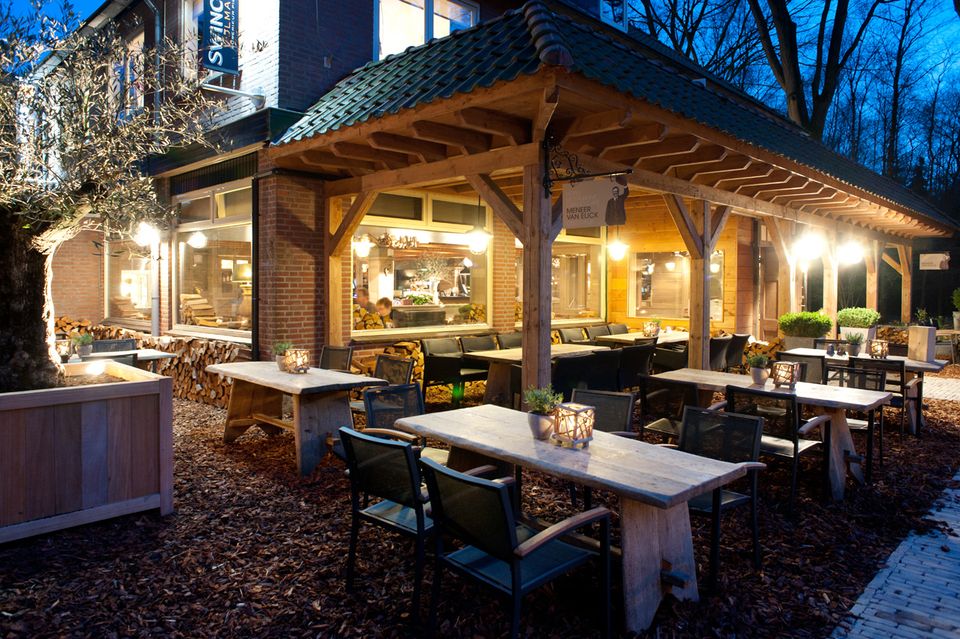 Terras voor het hotel-restaurant in de avond met verlichting.