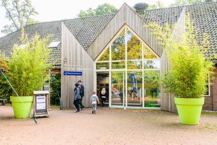 Moeder en kind lopen uit Bezoekerscentrum Gooi en Vechtstreek van Natuurmonumenten in 's-Graveland.