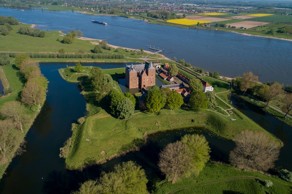 Een kasteel omgeven door vestingwerken en water gefotografeerd vanuit de lucht.