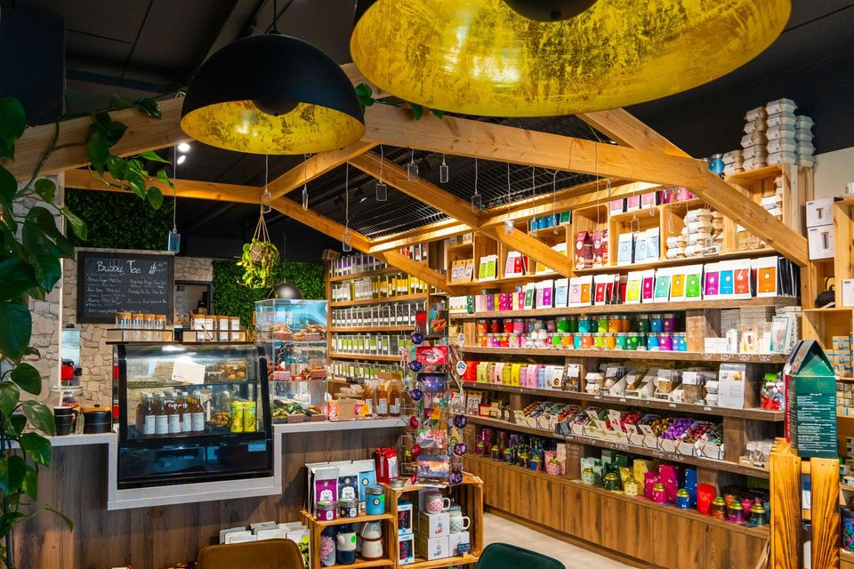 Speciaalzaak Amiza Tea Boutique Woerden, provincie Utrecht, Groene Hart, blikjes met losse thee en kaarten met ijsthee recepten op houten tafel in de theewinkel in het centrum.