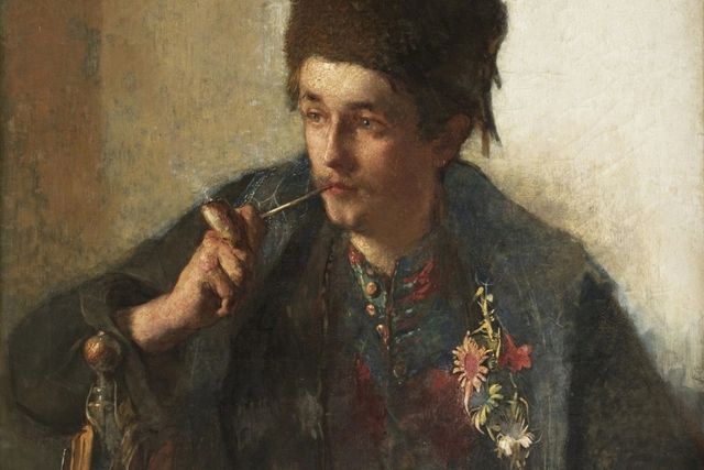 Portret van een jongeman in Hindelooper dracht met een leekstertak (schaatssouvenir) op zijn jas