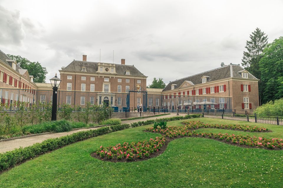 Slot Zeist gezien vanuit de aangelegde tuinen, met het hoofdgebouw, de zijvleugels en de monumentale toegangspoort. De foto laat de statige uitstraling en historische omgeving van Slot Zeist goed zien.