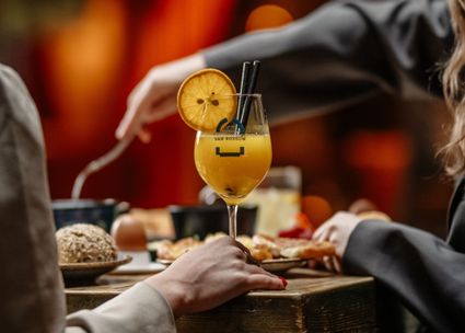 Restaurant Van Rossum in Woerden, Groene Hart, paasbrunch met cocktail met sinaasappel en brunchgerechten op tafel tijdens gezellig samenzijn in warme horecasfeer.