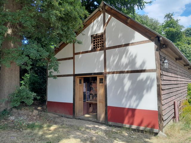 Gevel van een Romeins huis met vakwerk, in rood en wit, met in de gevel een vitrine met aardewerk.
