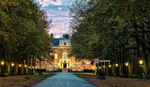 De zon gaat onder achter Slot Zeist en zorgt voor een lila gekleurde lucht