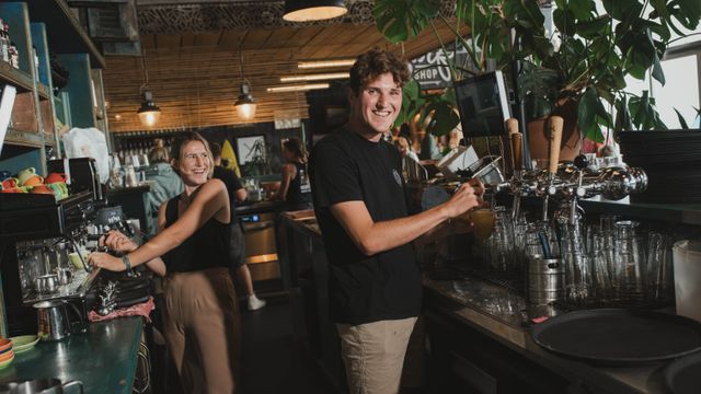 Tim staat achter de bar en tapt een biertje