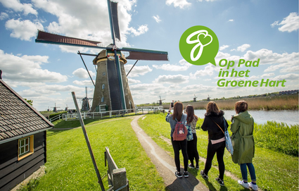 Campagne op pad in het groene hart; wandelaars bij molen in Kinderdijk