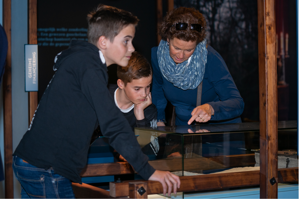 Moeder bekijkt met haar beide zoons een bezienswaardigheid in het museum Proefkolonie Frederiksoord.