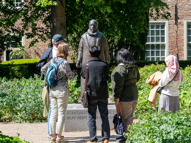 Een groepje mensen kijkend naar het standbeeld van Willem van Oranje in Delft