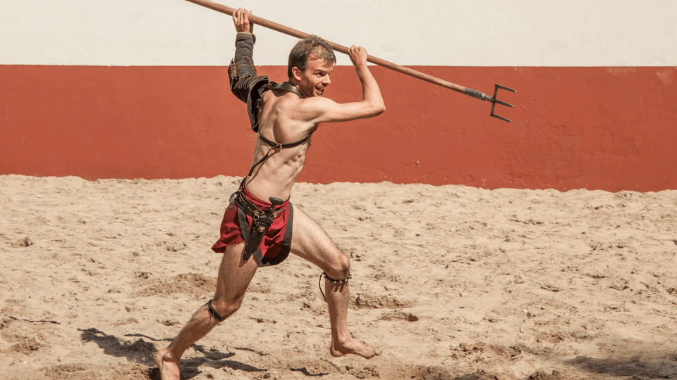 Een gladiator met een lange vork tijdens gladiatorgevecht tijdens voorstelling in Archeon