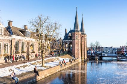 IJs rondom de Waterpoort in Sneek en schaatsende mensen