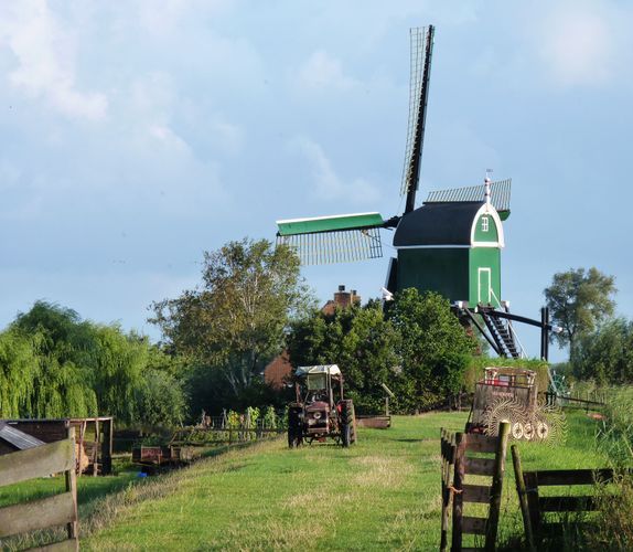 Groene poldermolen met tractor en boerenlandschap in Bodegraven-Reeuwijk, een typisch beeld van het landelijke Groene Hart.