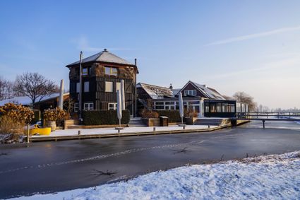 Winterse aanblik van Boerderij De Boerinn in Kamerik met besneeuwd erf en bevroren water, ideale sfeer voor het Winter Boerinn-arrangement.