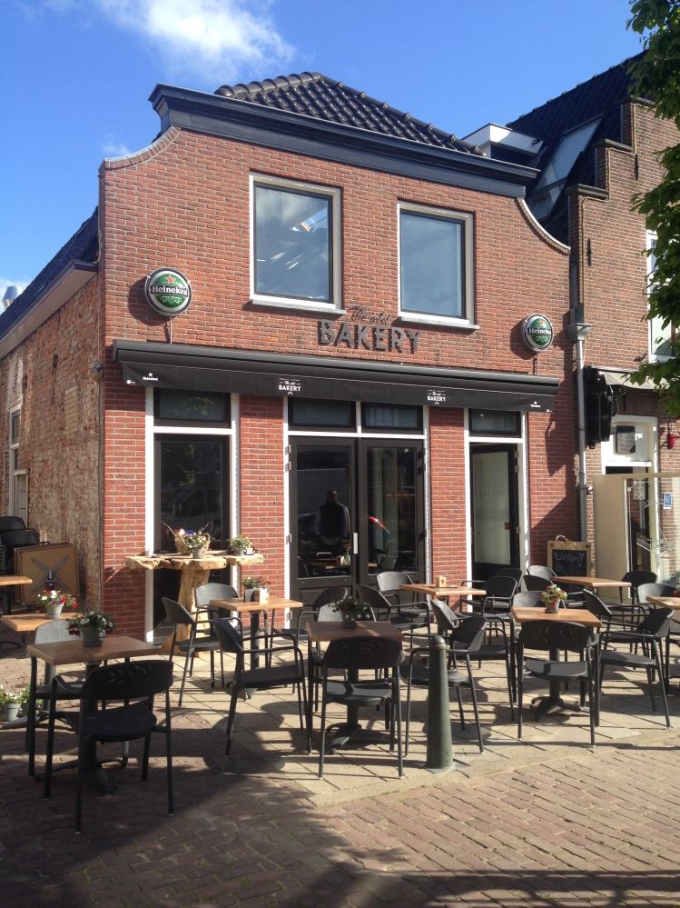 Horecagelegenheid The Old Bakery in Montfoort, Groene Hart, karakteristiek bakstenen pand met terras en tafels op het plein, zichtbaar als café-restaurant in het historische centrum.