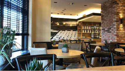 Sfeervol interieur van Bakkerij Versluis in Woerden met zitplaatsen, houten tafels en moderne bakkerij-uitstraling.