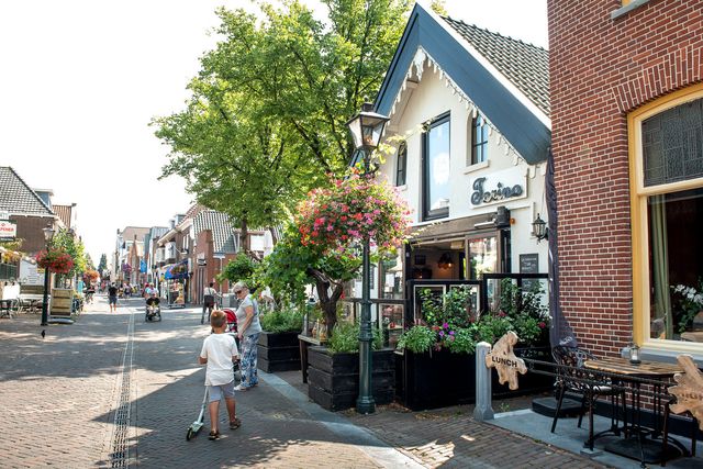 De Dorpsstraat met kinderen die er doorheen lopen.