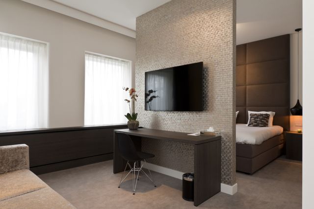 Lichte, moderne, luxe, hotelkamer met TV.