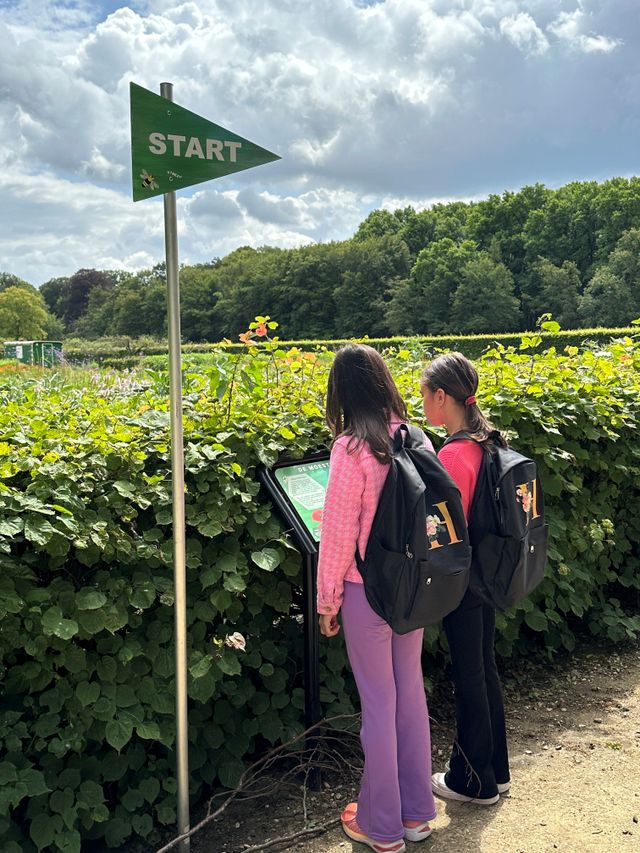 Twee kinderen doen een speurtocht in de tuinen Kasteel Groeneveld