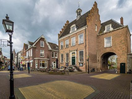 Historisch stadhuis Oud Montfoort in Montfoort, Groene Hart, monumentaal stadhuis met karakteristieke trapgevel, stadspoort en terras aan het sfeervolle historische marktplein.