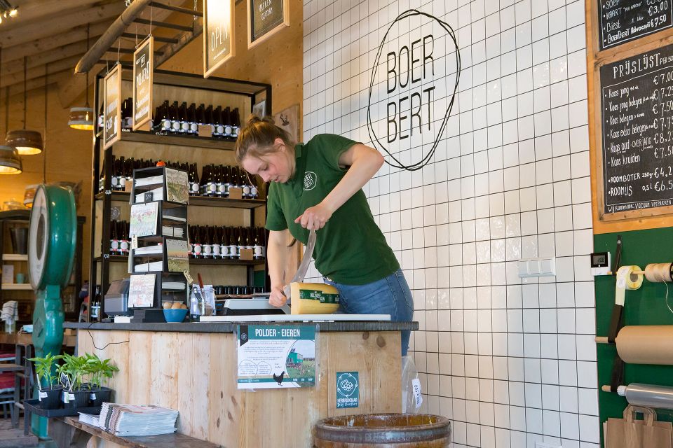 Medewerker in de boerderijwinkel van BoerBert, waar streekproducten en duurzame producten worden verkocht, een lokale winkelbeleving in het Groene Hart.