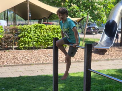 kind aan duikelrek in speeltuin