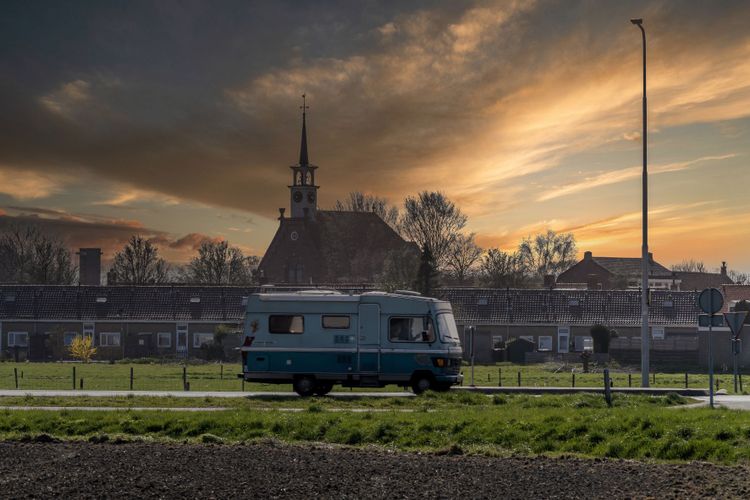Op-Schouwen-Duiveland-Kerkwerve-Stormachtige-Dag-Met-Zonsondergang-Met-Camper-Voor-Het-Dorp