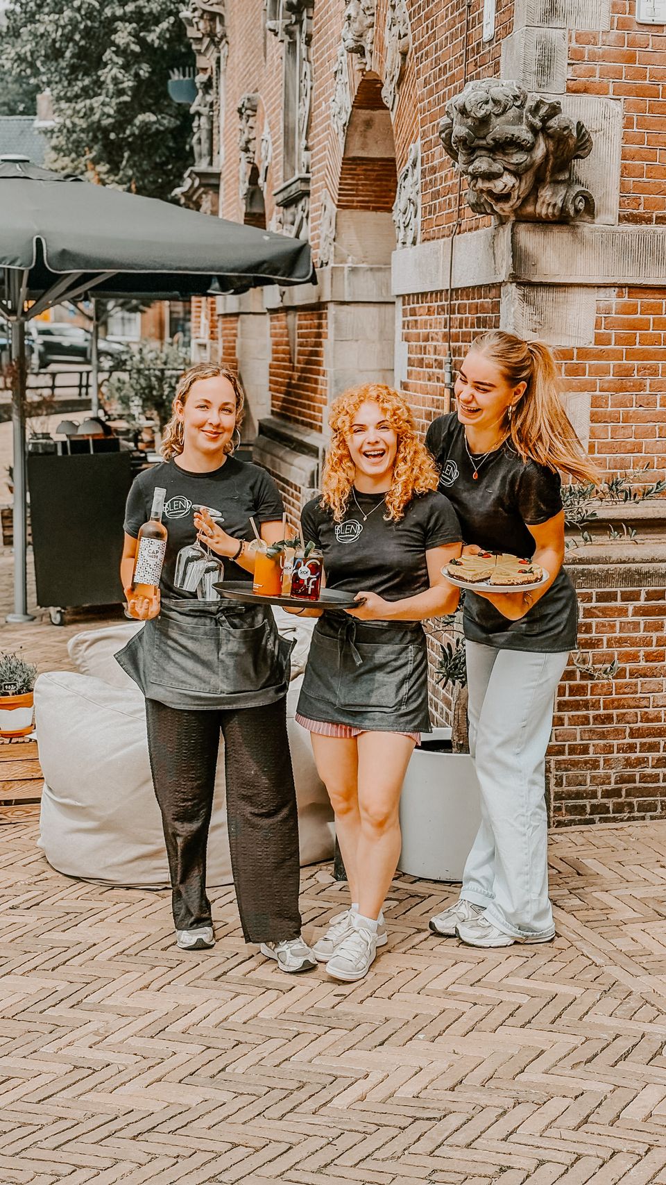 Drie medewerkers van Blend in Bolsward poseren voor de foto buiten voor het gebouw.
