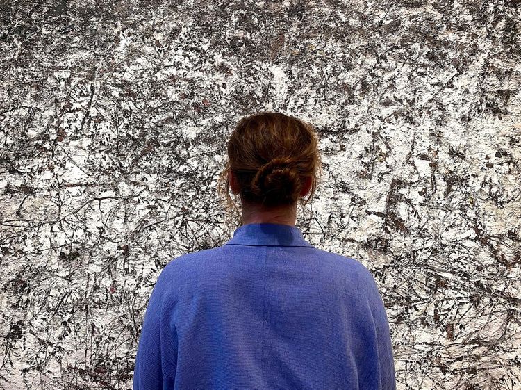 Vrouw met gezicht naar muur met kunst