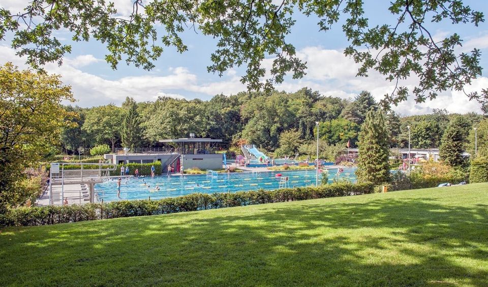 Buitenbad Sijsjesberg in Huizen omringt door groen.