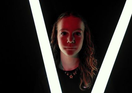Portret van meisje in rood en wit licht voor de voorstelling SPIJT! in Het Klooster Woerden.