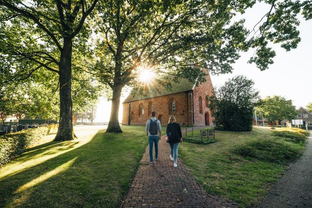 Ein Paar geht in Richtung der Kirche in Zweeloo.