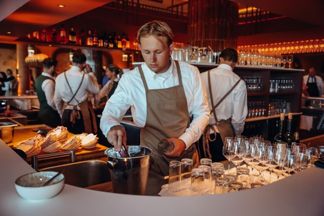Hotel Van der Valk Woerden, Woerden, Groene Hart, bediening achter de open bar met glazen, wijn en verse gerechten in een sfeervol en modern restaurant.