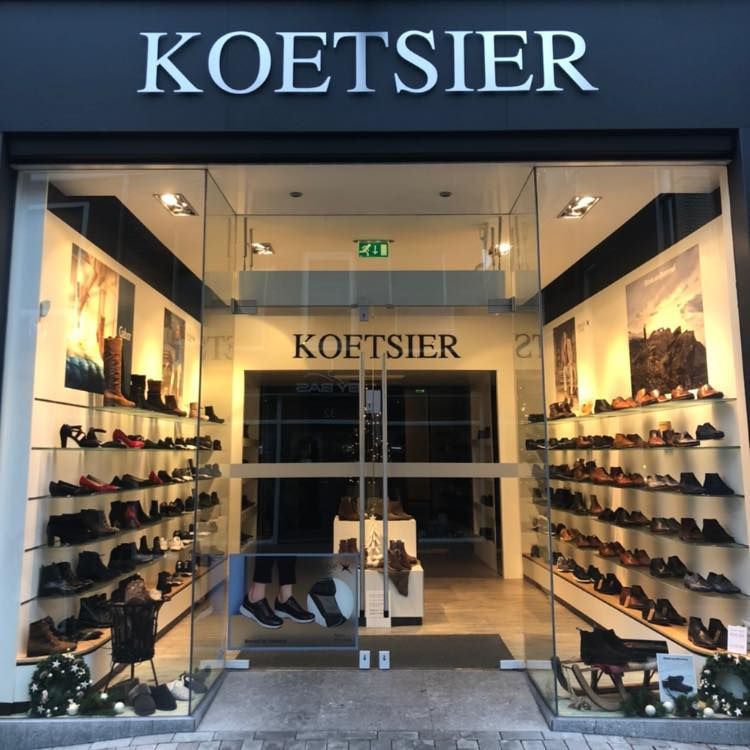 Speciaalzaak Koetsier Schoenen Woerden, provincie Utrecht, Groene Hart, winkelgevel met glazen deuren en wandpresentaties met leren schoenen en laarzen in het centrum.